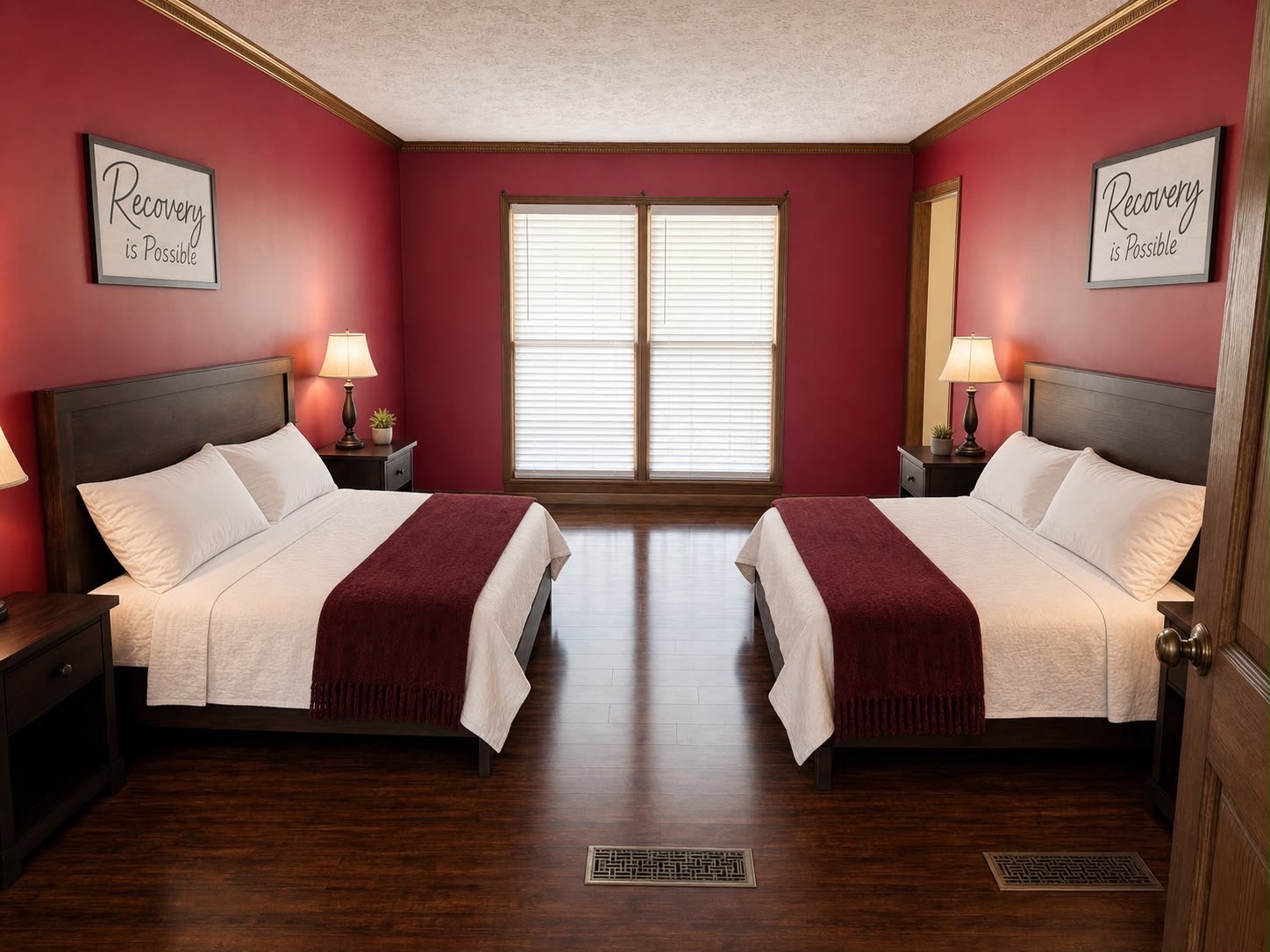 Red bedroom with 2 full-size beds, deep crimson walls and motivational artwork